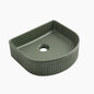 Green ceramic sink basin with ribbed design on a white background
